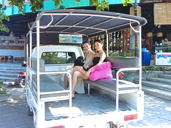 レンボンガン島特有の車に乗車して笑顔の2名の仲良し女性モデル