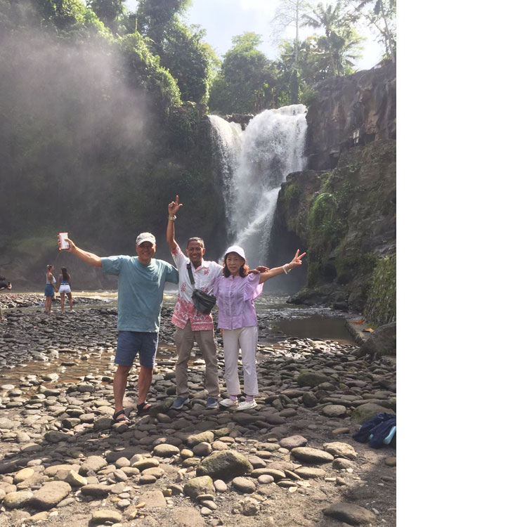 トゥグヌンガンの滝にてガイドと一緒に笑顔で記念撮影をするお客様夫婦