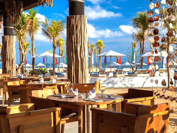 青い空と白い砂浜とプールに隣接するレストランの席
