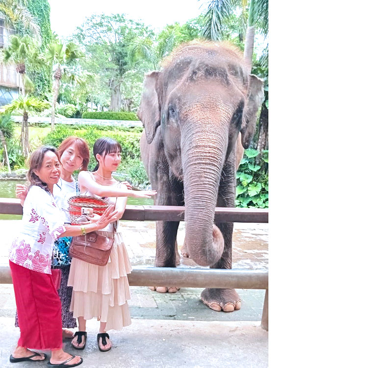 女性ガイドのアルティニとバリズーの象さんと一緒に記念撮影をする笑顔のお母さんと娘様