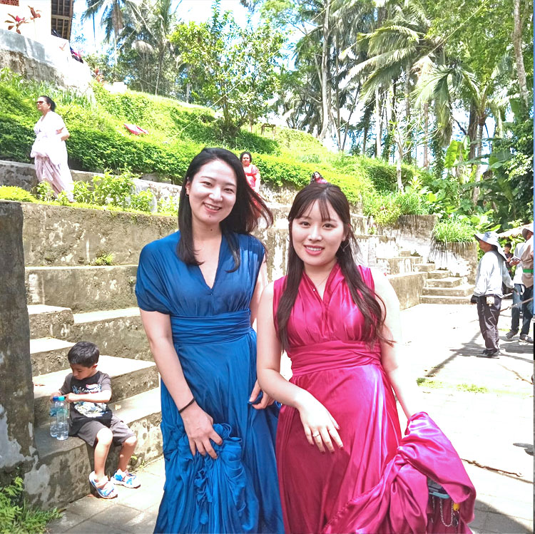 テガラランのライステラスに映えるブルー＆レッドのドレスを着て笑顔の仲良しの女性2人組