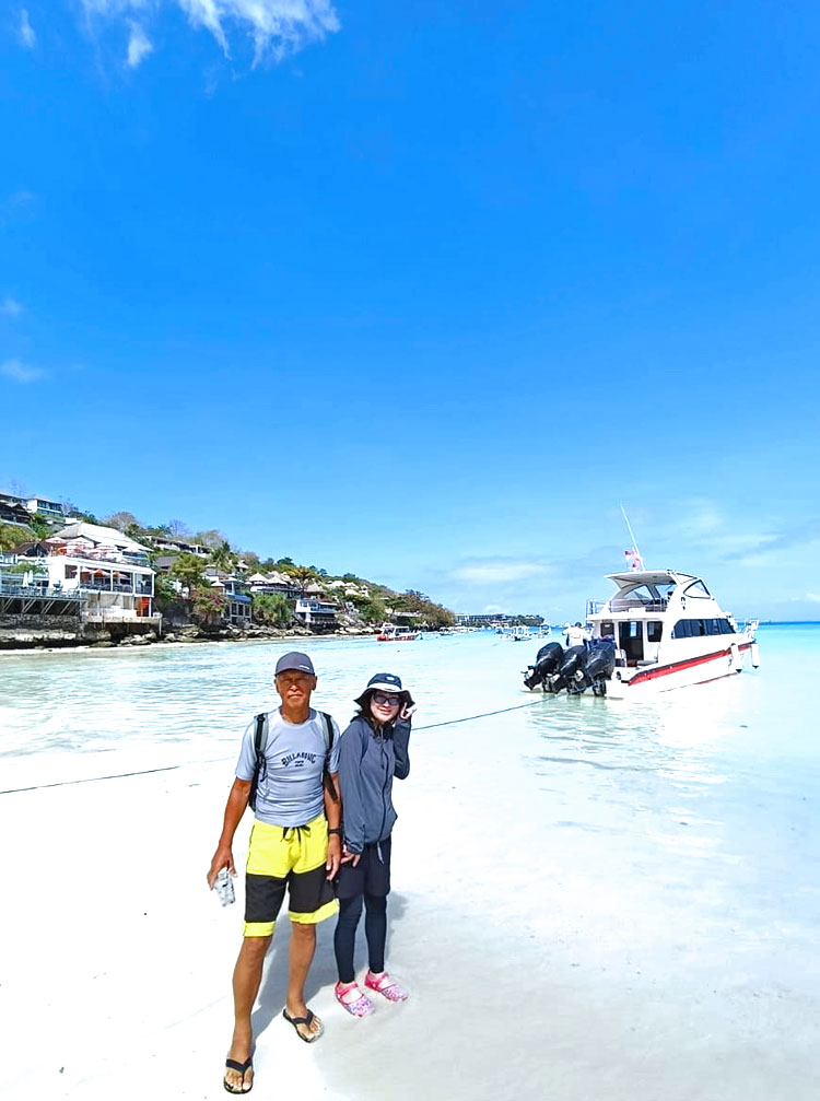レンボンガン島のビーチに立つご夫婦