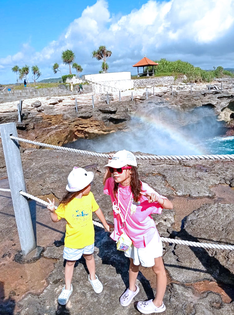 デビルティアーズで波しぶきが虹色にかかやくなかで記念撮影をするかわいい姉妹のお子様