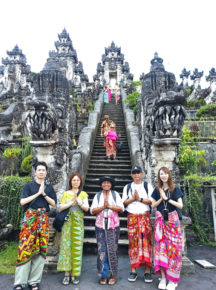 ランプヤン寺院で記念撮影をするご家族様とバリ姫の女性ガイド