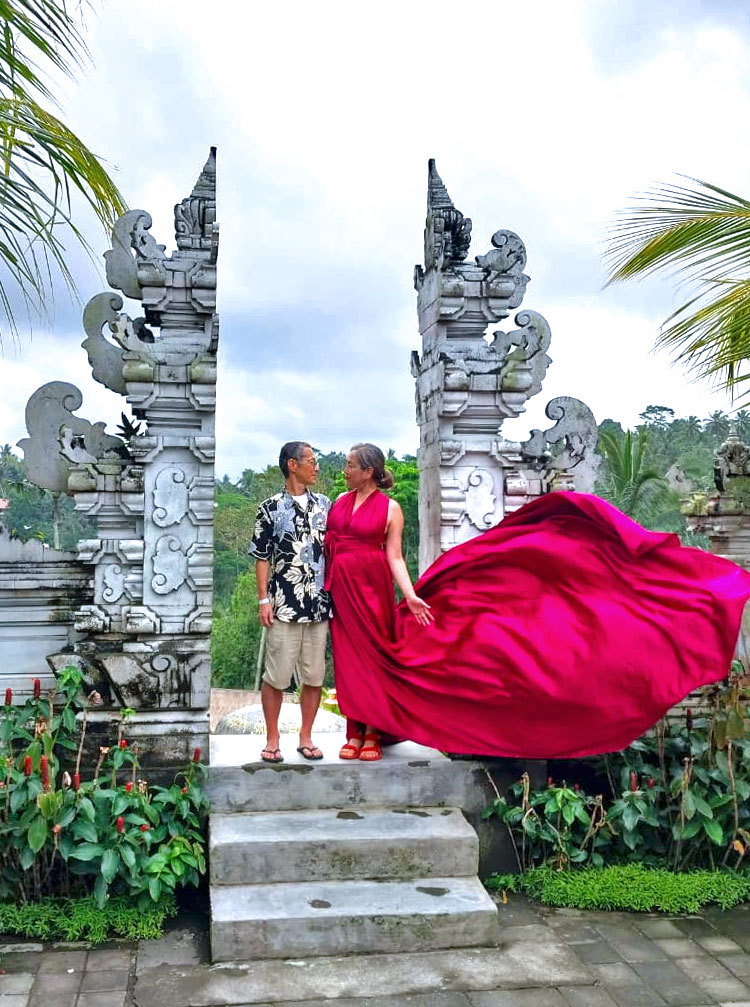 真っ赤なドレスが風になびき、割れ門で向き合うご夫婦