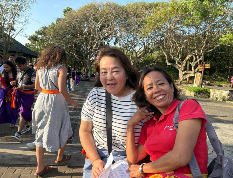 バリ姫の女性ガイドと一緒に記念撮影をする女性1人でご参加されたお客様