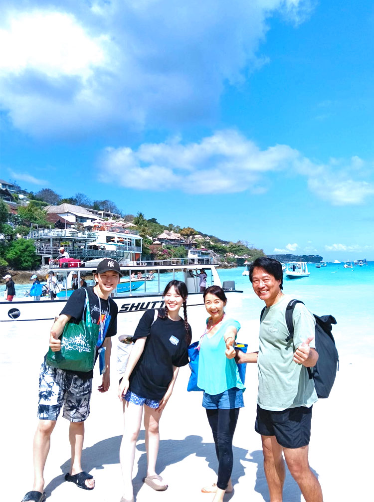 天気の良いレンボンガン島のキレイなビーチでポーズをとる笑顔の4人家族様