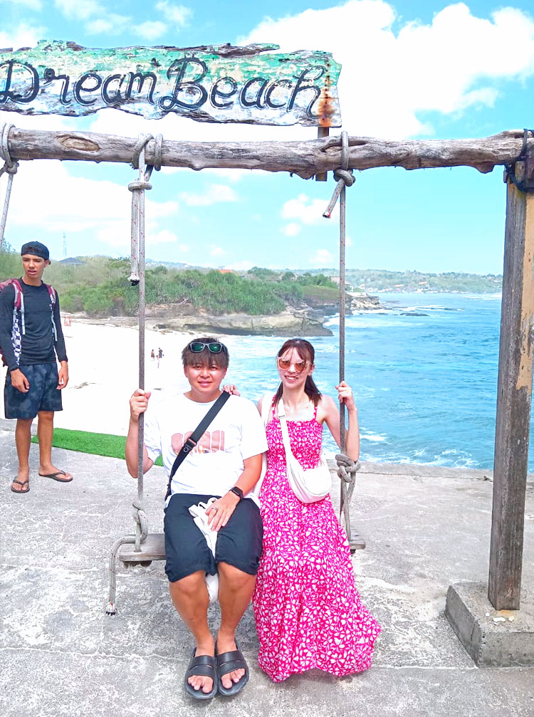 ドリームビーチの映えスポットのブランコにのって笑顔のカップル