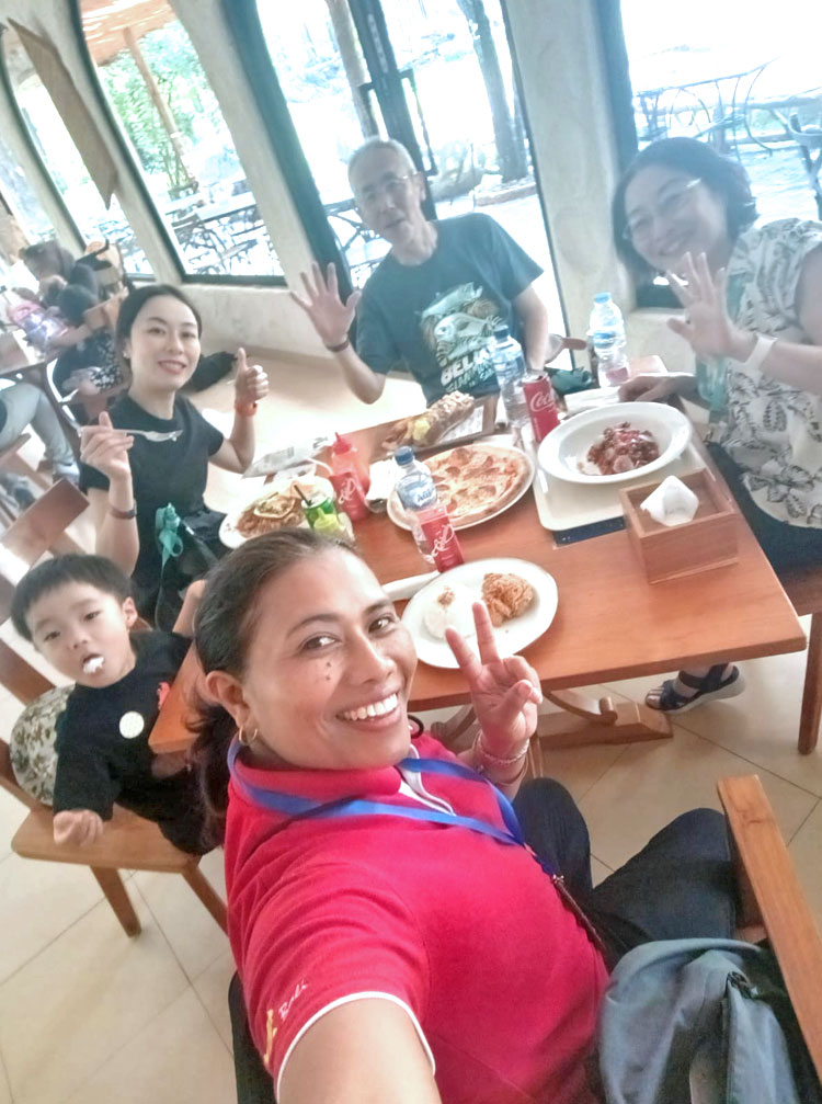 ファミリーとバリ姫の明るい女性ガイドが和気あいあいとランチする様子