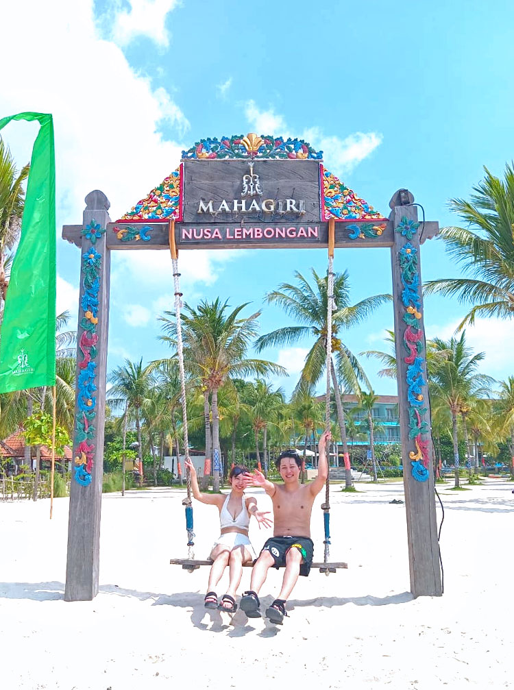 レンボンガン島のマハギリリゾートの写真映えスポットのブランコにのって手をふる笑顔のカップル