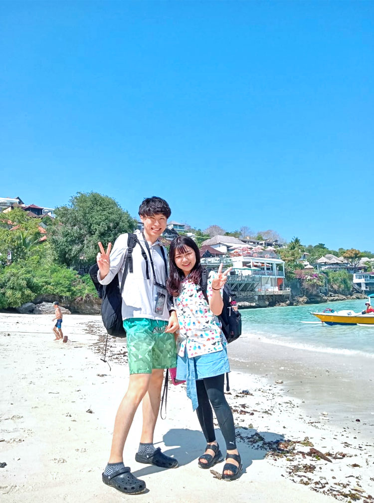 天気の良いレンボンガン島のキレイなビーチでポーズをとるカップル