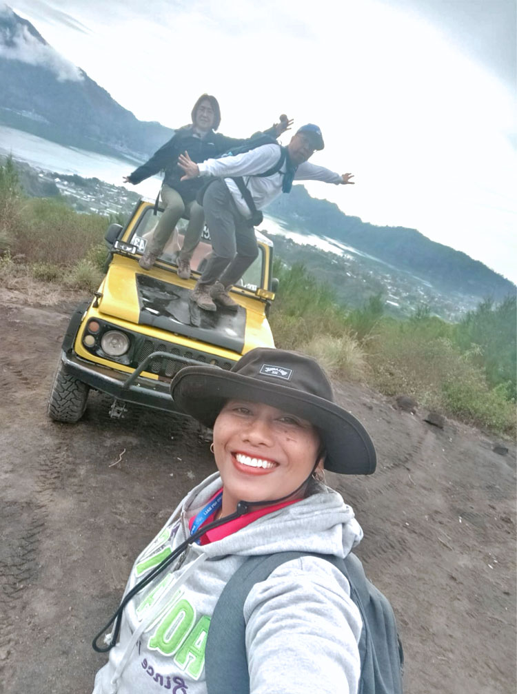 キンタマーニ高原のバトゥール山サンライズトレッキングに参加されるお客様と一緒に笑顔のバリ姫女性ガイド