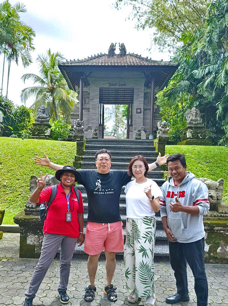 割れ門で記念撮影をするご夫婦様とドライバー＆女性ガイドのバリ姫スタッフ
