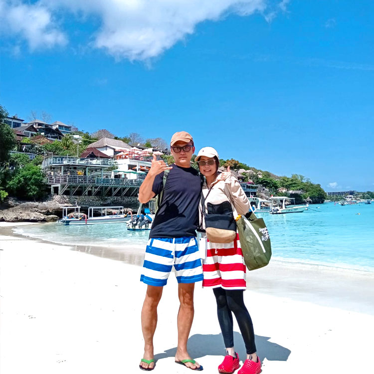 天気の良いレンボンガン島のキレイなビーチでポーズをとるカップル