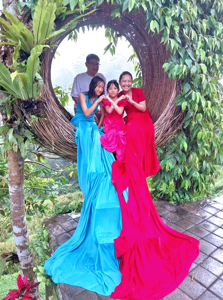 インスタ映えスポットでドレスを着て記念撮影をする笑顔のファミリー