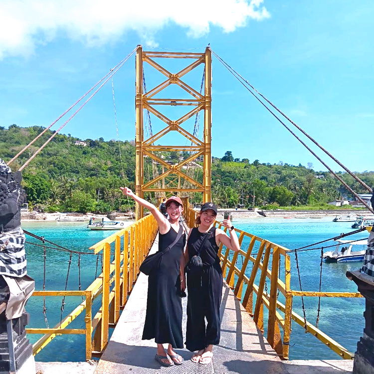 レンボンガン島のイエローブリッジで笑顔でポーズをとる仲良しの女性2人組