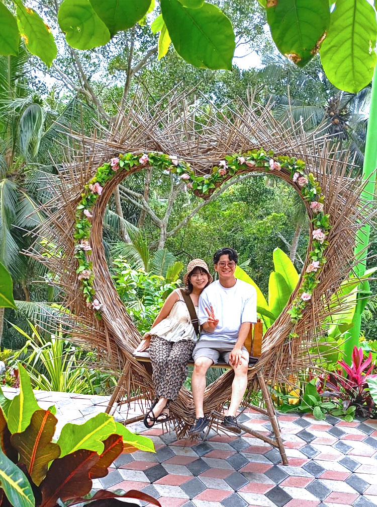 ハートのモチーフに入って記念撮影をする笑顔のカップル