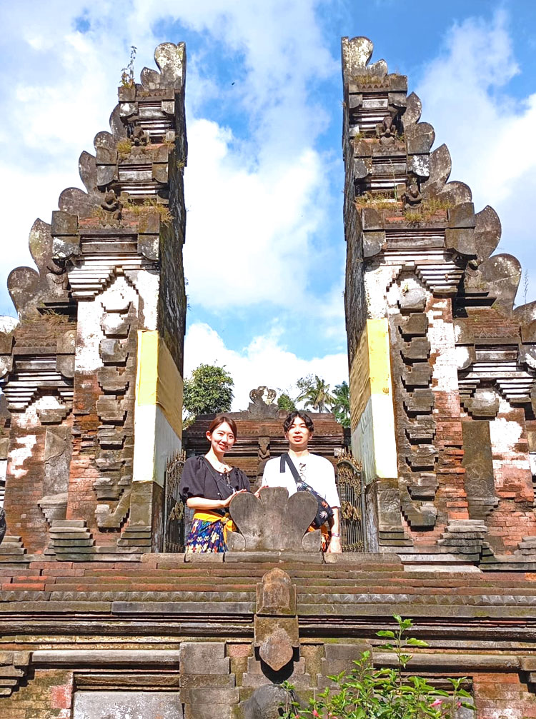 割れ門の間に立って記念撮影をするカップル