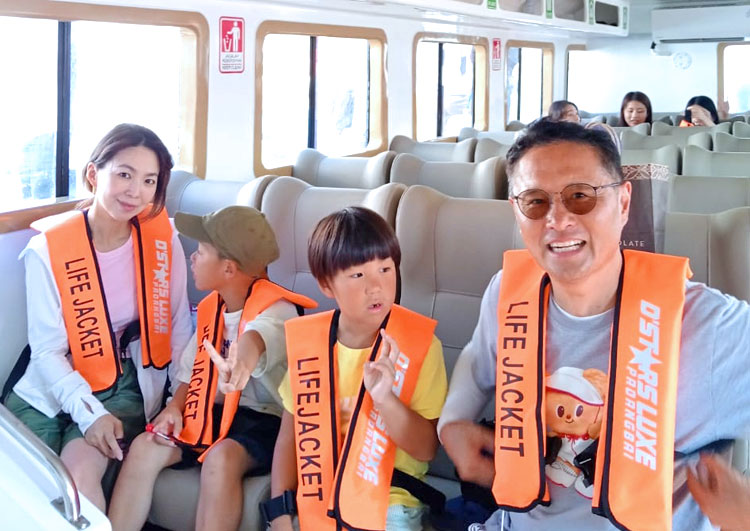 スピードボートに乗りライフジャケットをしっかりと装着するパパさんママさんと2人のお子様