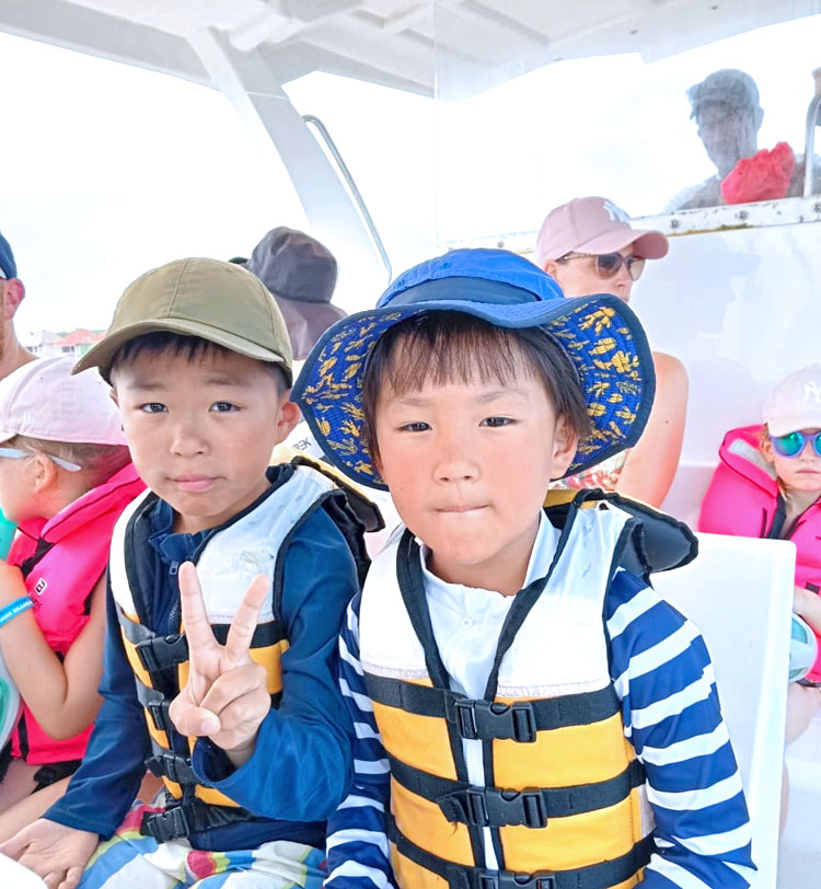 マンタシュノーケリングに出発し、ボート上で他の欧米のファミリーさんと同い年のお子様と一緒に緊張した面持ちに2人のお子様