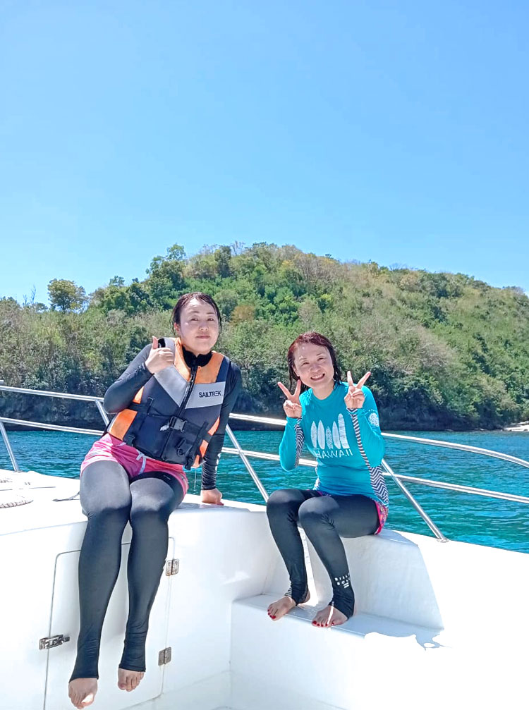 シュノーケリング船上でピースをする女性2名のお客様