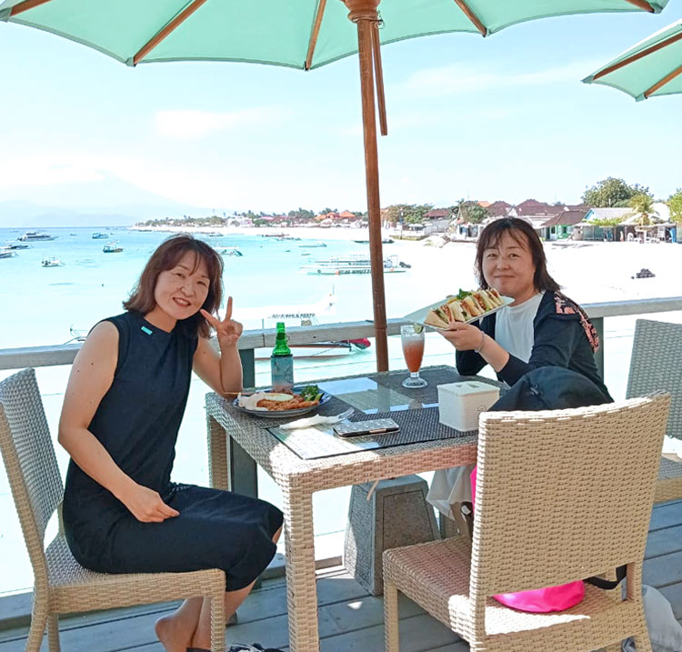 レンボンガン島のビーチを見渡せるルーフトップバーでランチを楽しむ女性2名のお客様
