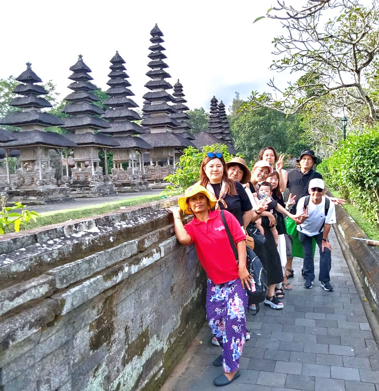 タマンアユン寺院をご案内するバリ姫の女性ガイドと笑顔のご家族様