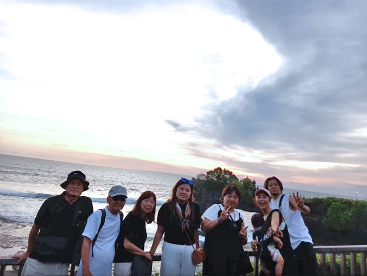 夕日のタナロット寺院をバックに記念撮影をするご家族様